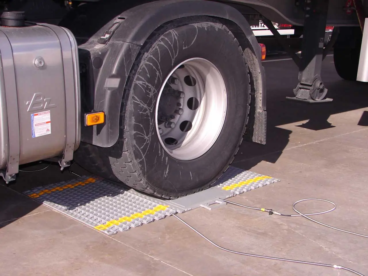 Truck being weighed on portable axle pads
